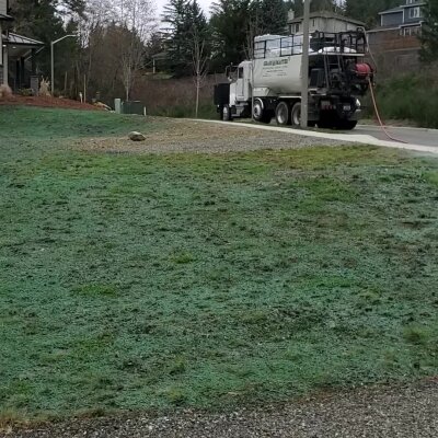 Industrial truck parked on side of road near grassy area.