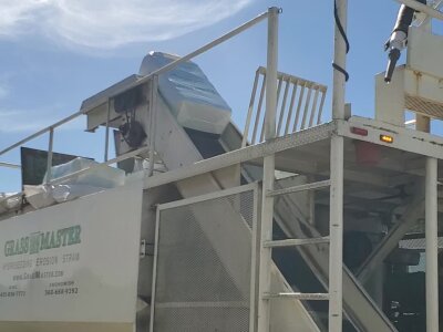 Industrial straw blower machine on a sunny day.