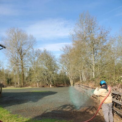 Worker applying hydroseed mixture to lawn in Washington state.