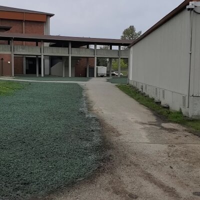 Industrial complex with buildings, pathway, and green ground cover.