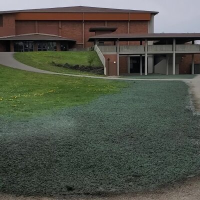 Modern building with glass entrance and landscaped lawn.