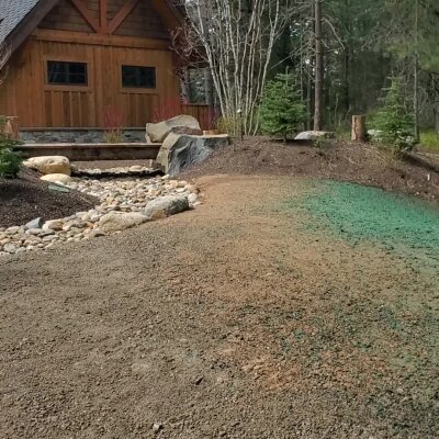 Rustic wooden cabin with landscaped garden and gravel path.