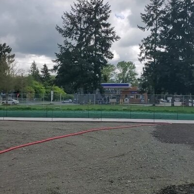 Prepared soil for hydroseeding with trees and fencing in Washington state.