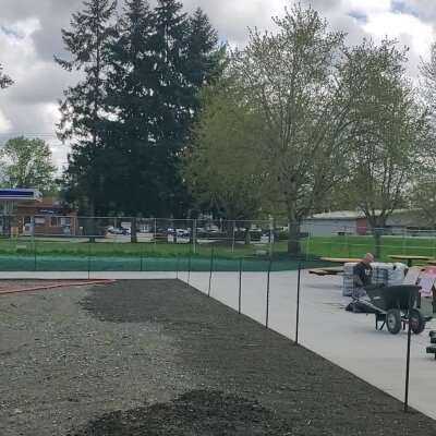 Prepared lawn with hydroseeding equipment and technician in Washington.