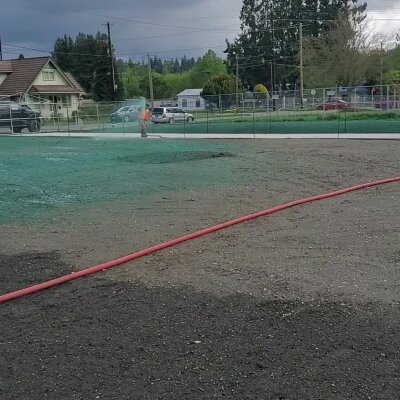 Worker applying hydroseed mixture on a lawn in Washington State.