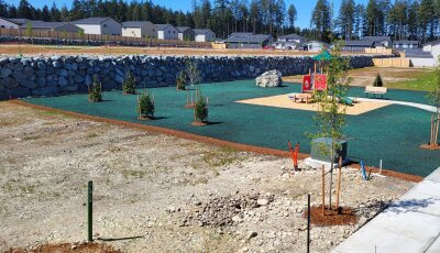 Hydroseeded lawn at new housing development with playground and retaining wall.