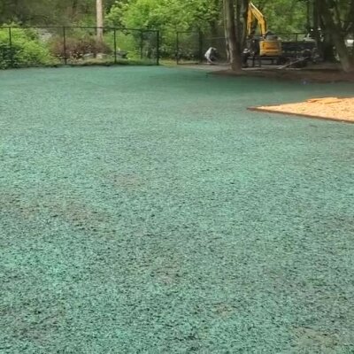Freshly applied green hydroseed covering a large residential lawn area.