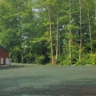 Newly treated erosion control spray applied on soil near wooded area.