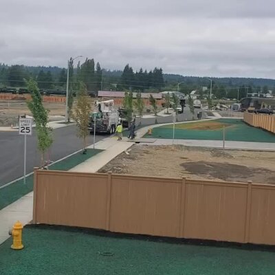 Hydroseed installation on newly developed residential streets with workers and equipment.